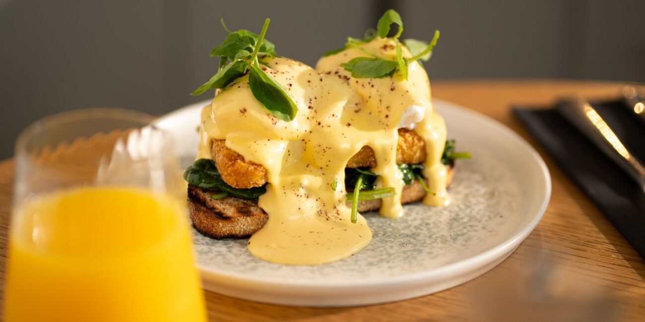Poached eggs with hollandaise, greens and toast promoting the student buffet breakfast offer at Ember & Vine in Mawson Lakes, Adelaide
